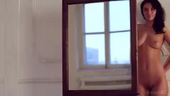 Redă Adolescentă senzuală cu părul închis se face plăcere în fața oglinzii
